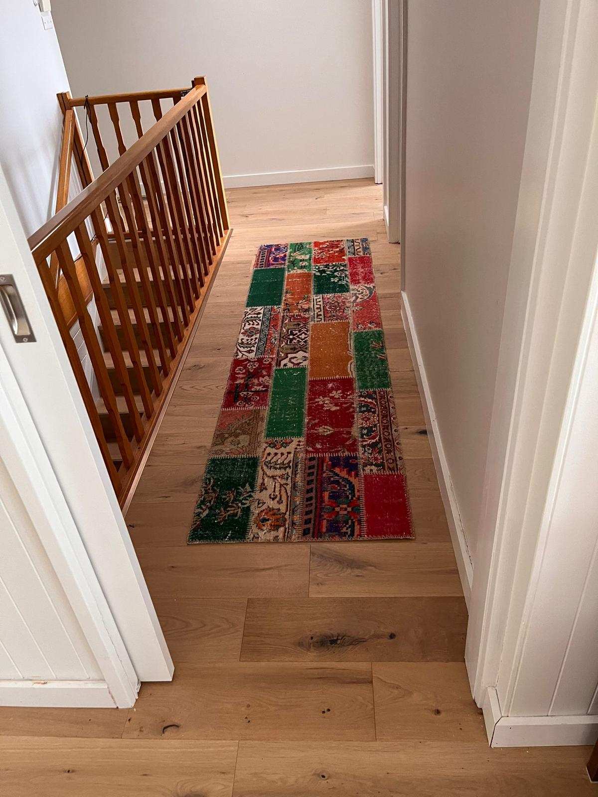 Timber flooring hallway with colourful rug in Yarralumla home