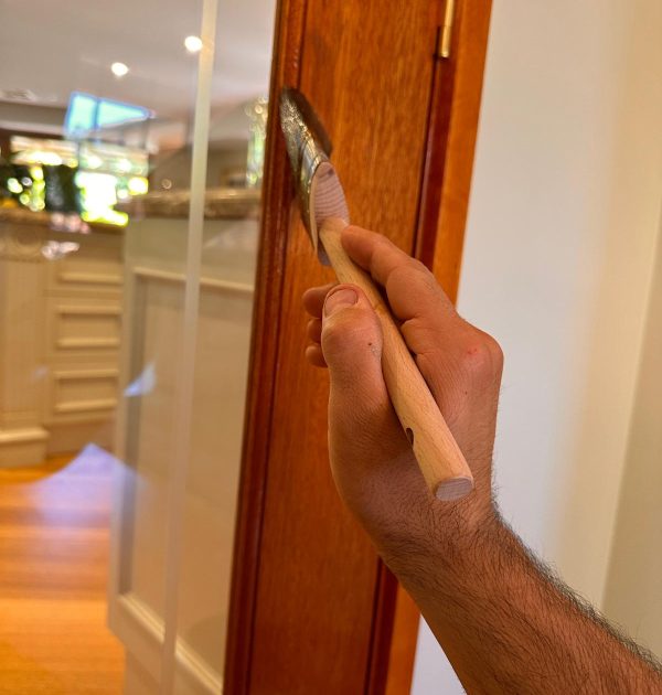 Hand-applied polish on timber door frame in Woden Valley